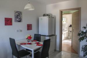 a kitchen with a table and a white refrigerator at Ferienwohnung Haus am Wald in Judenbach