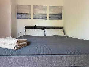 a bedroom with a bed with three paintings on the wall at Falterweg in Immenstaad am Bodensee +8 photos