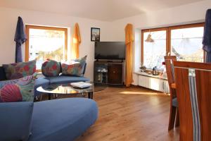 a living room with a blue couch and a table at Ferienwohnung Jule in Sonthofen