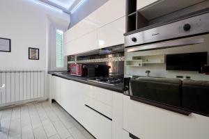 a kitchen with white cabinets and a black counter top at Holy days in Piombino