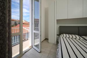 a bedroom with a bed and a balcony with a view at Holy days in Piombino