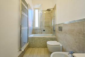 a bathroom with a toilet and a tub and a sink at Holy days in Piombino +18 photos