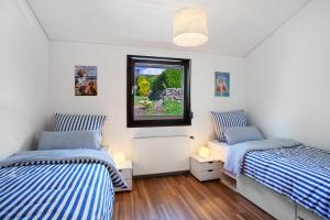 two beds in a room with blue and white stripes at Ferienhaus Sauerland am Hennesee in Meschede