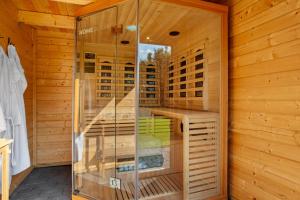 a sauna with a glass shower in a wooden cabin at Ferienhaus Sauerland am Hennesee in Meschede +35 photos