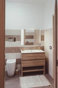 a bathroom with a sink and a toilet and a mirror at Domus del Gotha in Mazzarino +42 photos