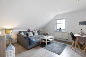 a living room with a couch and a table at Ferienwohnung Huus 39 in Ostenfeld