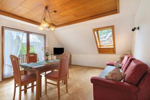 a dining room with a table and a couch at Sulzerhof in Bad Rippoldsau-Schapbach