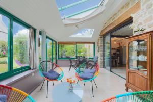 a conservatory with two chairs and a table in a room at Gite les coquelicots Proche mer in Paimpol