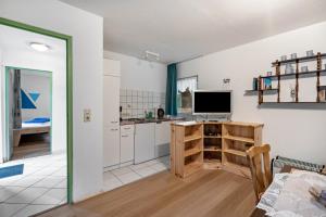 a kitchen with a desk and a tv in a room at Bungalow 15 - Finnhütte in Niesky