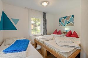 three beds in a room with a window at Bungalow 15 - Finnhütte in Niesky