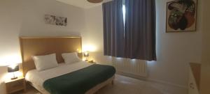 a bedroom with a bed and two lamps and a window at Appartement Duplex Rez Jardin in Montbrun-les-Bains +22 photos