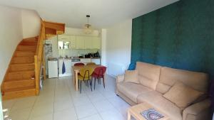 a living room with a couch and a table with chairs at Appartement Duplex Rez Jardin in Montbrun-les-Bains