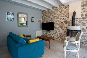 a living room with a blue couch and a fireplace at Gite les coquelicots Proche mer in Paimpol