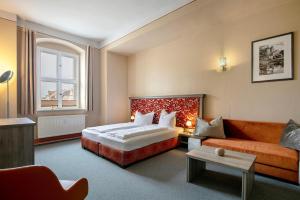 a hotel room with a bed and a couch at Luckau Appartements 1695 in Luckau
