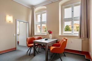 a room with a table and chairs and windows at Luckau Appartements 1695 in Luckau