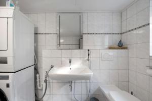 a white bathroom with a sink and a mirror at Haus Seezeit in Freilingen +20 photos