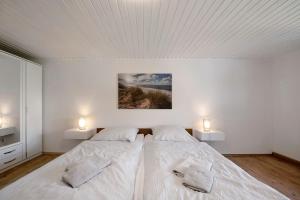 a white bedroom with a large bed with two pillows at Haus Seezeit in Freilingen