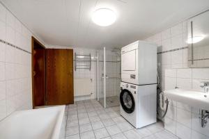 a bathroom with a washer and a sink and a refrigerator at Haus Seezeit in Freilingen