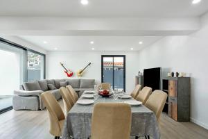 a dining room with a table and chairs and a couch at Villa Angela in Funchal