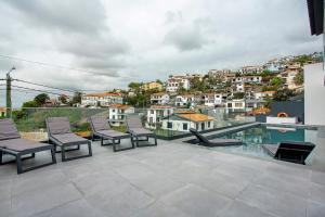 a balcony with chairs and a view of a city at Villa Angela in Funchal