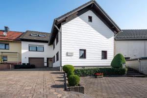 a large white house with a brick driveway at Haus Seezeit in Freilingen