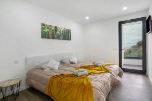 a bedroom with two beds with yellow blankets at Villa Angela in Funchal +33 photos