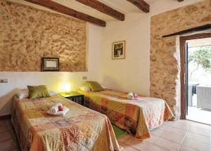 two beds in a room with a stone wall at Cadernera in Búger +20 photos