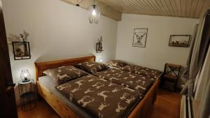 a bedroom with a bed with a comforter and pillows at Sauerland Alm Winterberg 5 mit Pool in Hallenberg +21 photos