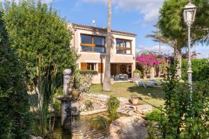 a house with a fountain in front of a garden at Finca Can Jeroni in Felanitx
