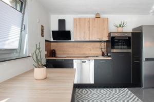 a kitchen with a black refrigerator and a sink at Casa Ruf in Orsingen-Nenzingen