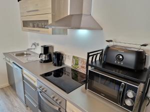 a kitchen with a stove and a microwave at Wohnung Barbarossa in Rommelhausen +9 photos