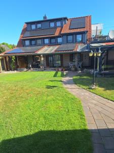 ein großes Haus mit einem Rasen davor in der Unterkunft Bei Oparius in Ganderkesee