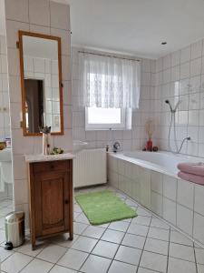 ein Badezimmer mit Badewanne und einer Katze, die auf einem Tisch sitzt in der Unterkunft Bei Oparius in Ganderkesee + 30 Fotos