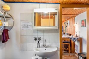 a bathroom with a sink and a mirror at Ferienwohnung Kleiner Strandfloh in Wangerooge +12 photos