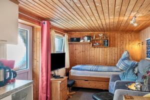 a small room with a bed and a couch and a tv at Ferienwohnung Kleiner Strandfloh in Wangerooge