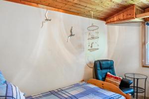 a bedroom with a bed and a chair at Ferienwohnung Kleiner Strandfloh in Wangerooge