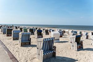 a row of beach chairs on the beach at Ferienwohnung Kleiner Strandfloh in Wangerooge