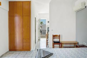 a bedroom with a wooden cabinet and a chair at Athina seaside in Kardamaina