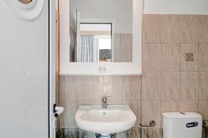 a bathroom with a sink and a mirror and a toilet at Athina seaside in Kardamaina +16 photos