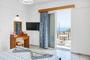 a bedroom with a bed and a desk and a window at Athina seaside in Kardamaina