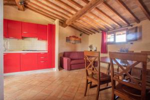 a kitchen with red cabinets and a red couch at Appartamento Capraia in Riotorto