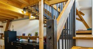 a kitchen with a black counter and a wooden staircase at St Georgen Ferienwohnung 1 in Freiburg im Breisgau