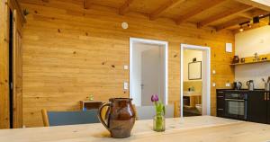 a kitchen with wooden walls and a table with a vase on it at St Georgen Ferienwohnung 1 in Freiburg im Breisgau +8 photos
