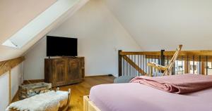 a bedroom with a bed and a flat screen tv at St Georgen Ferienwohnung 1 in Freiburg im Breisgau