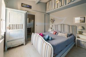 a bedroom with a bed with two chairs at Maison agréable et tranquille in Gujan-Mestras