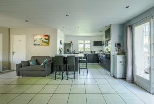 a living room and kitchen with a couch and a table at Maison agréable et tranquille in Gujan-Mestras