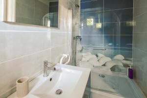 a bathroom with a sink and a glass shower at Maison agréable et tranquille in Gujan-Mestras +17 photos