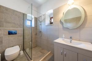 a bathroom with a toilet and a sink and a mirror at Old manor house in Syvota +88 photos