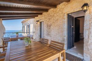 a wooden table on the balcony of a house at Old manor house in Syvota