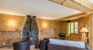 a living room with a fireplace in a wooden house at Ferme Le Coup d'Oeil in Taninges